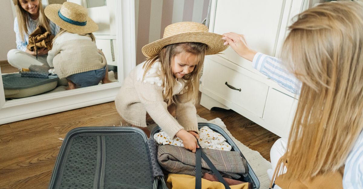 A mother and daughter pack a suitcase for a summer vacation, creating joyful memories.
